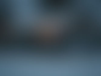 Green house covered in snow with twinkly lights inside