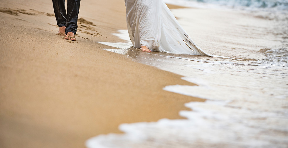 Bride and Groom walking on a beach after wedding ceremony