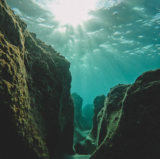 Sunlight filtering through clear water in the underwater caves of the Rosh Hanikra nature reserve.
