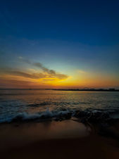 Vibrant sunset over the ocean with colorful sky reflecting in water.
