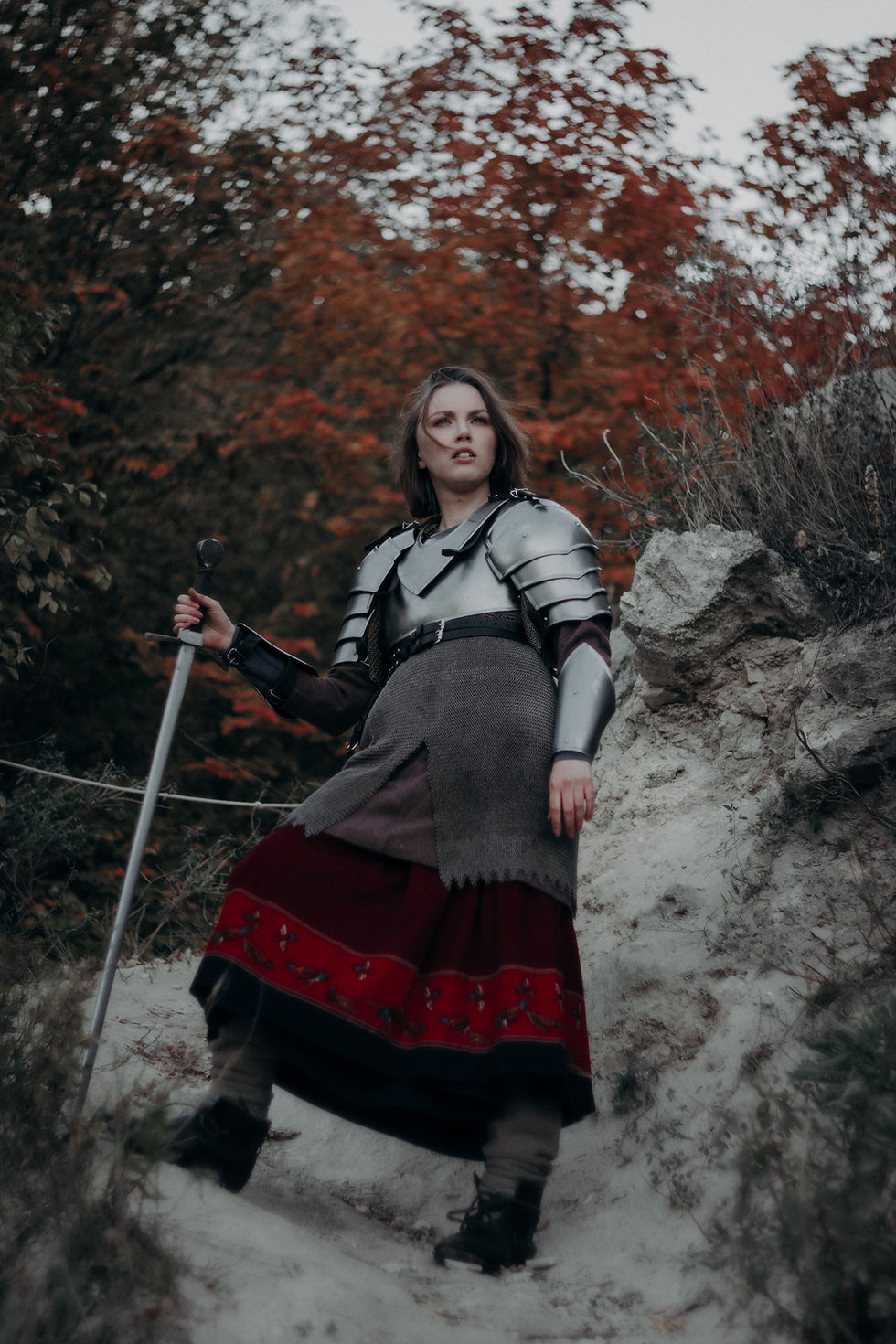 A woman dress in war outfit with a sword in hand