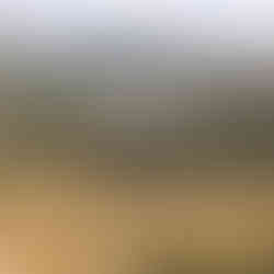 High-angle panoramic view of the fertile green fields and water reservoirs of the Jezreel Valley from a mountain lookout.