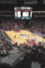 College basketball game at Save Mart Center, Bulldogs vs Cowboys, with players on court and crowd under a lit scoreboard.