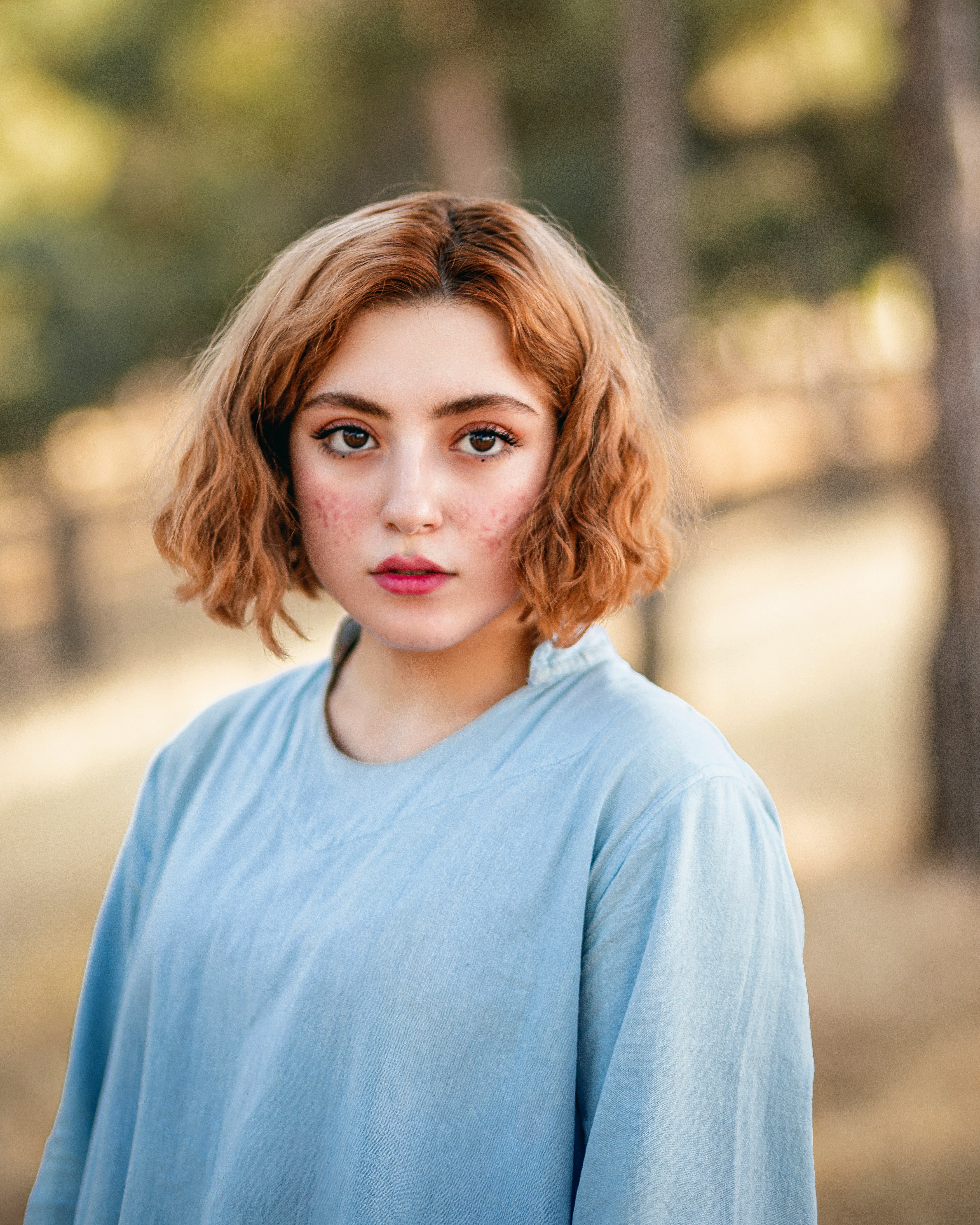 Portrait of a student with curly hair wearing a blue sweater