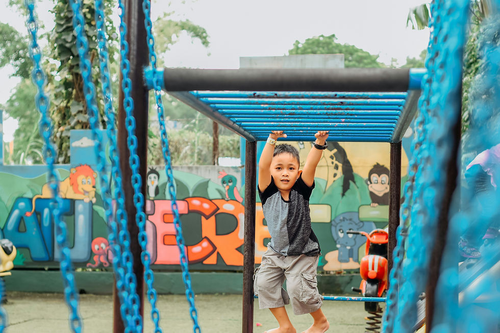 Child playing on blue monkey bars in a colorful playground with animal murals, smiling and focused. Bright, cheerful atmosphere.