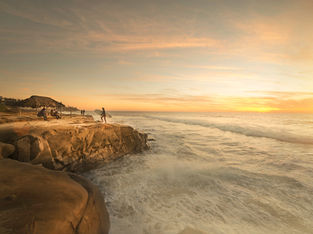 An image of a surfer and the ocean cliffs in San Diego