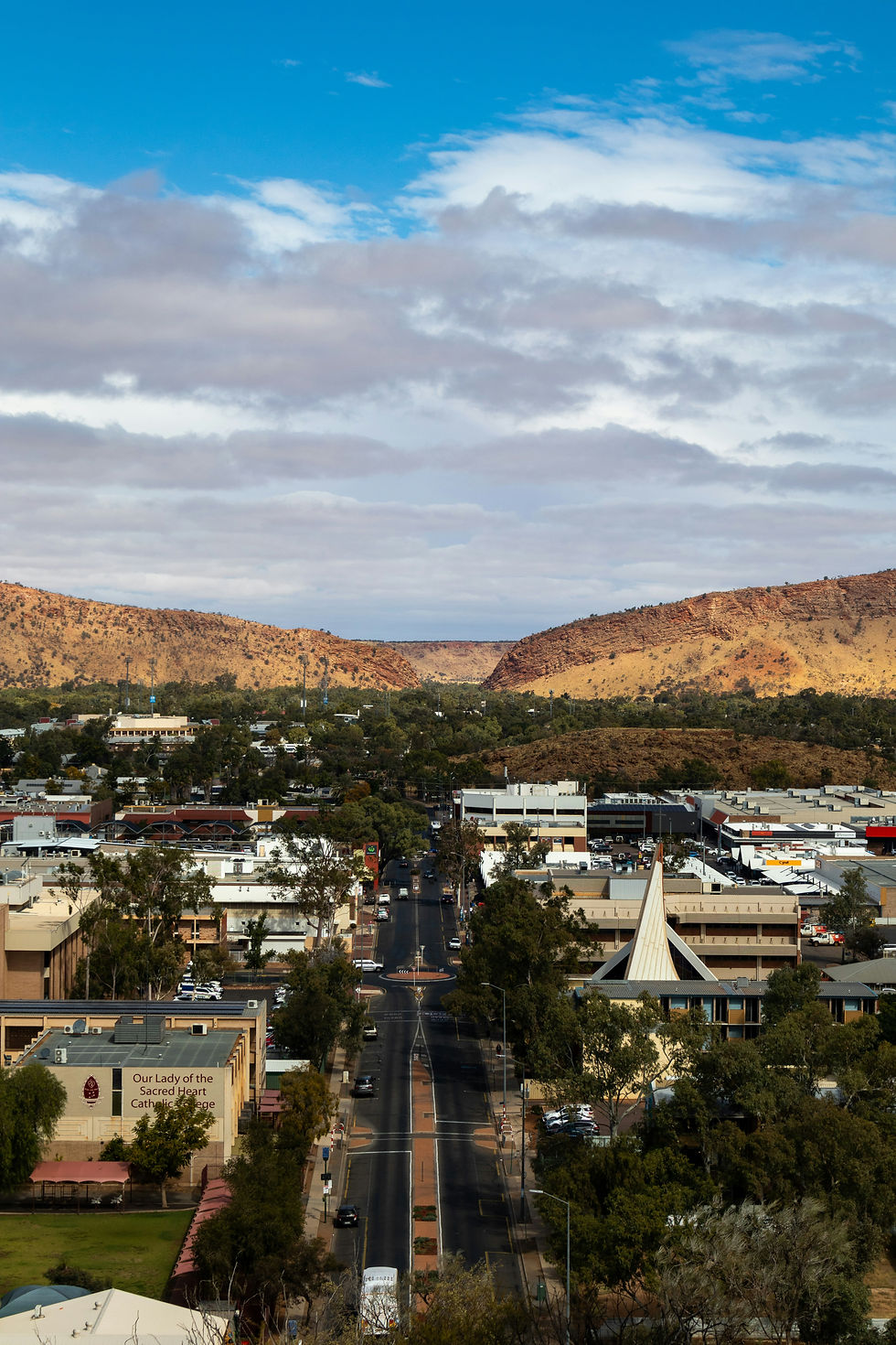alice springs town cbd on a cloudy day with green trees and busy streets