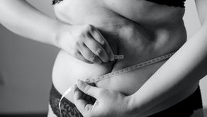 Person measures waist with tape in black and white photo. Wearing lace underwear, capturing introspective mood with focus on body positivity. Showing The Cortisol Belly Nobody Warned You About: Why Perimenopause Turns Stress Into Belly Fat. Vibrance Way