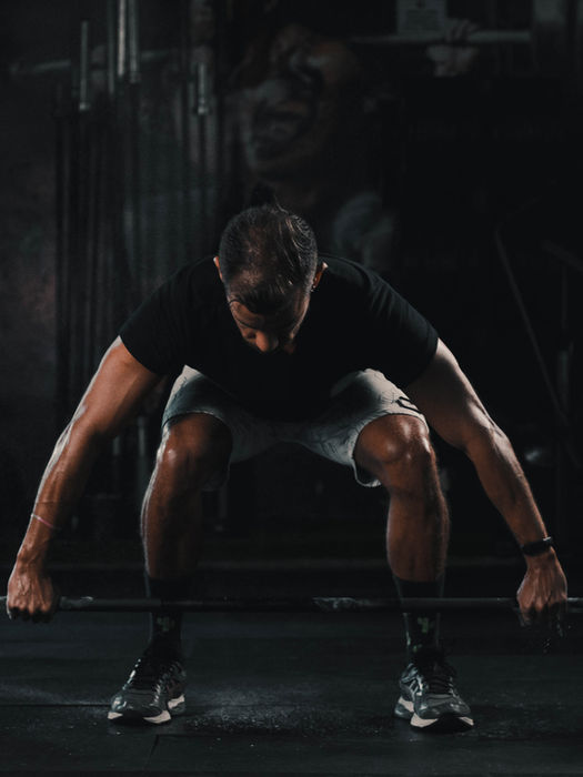 Man preparing for a barbell deadlift in a gym