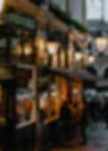 Image of the outside of a store with people walking past window shopping at night.