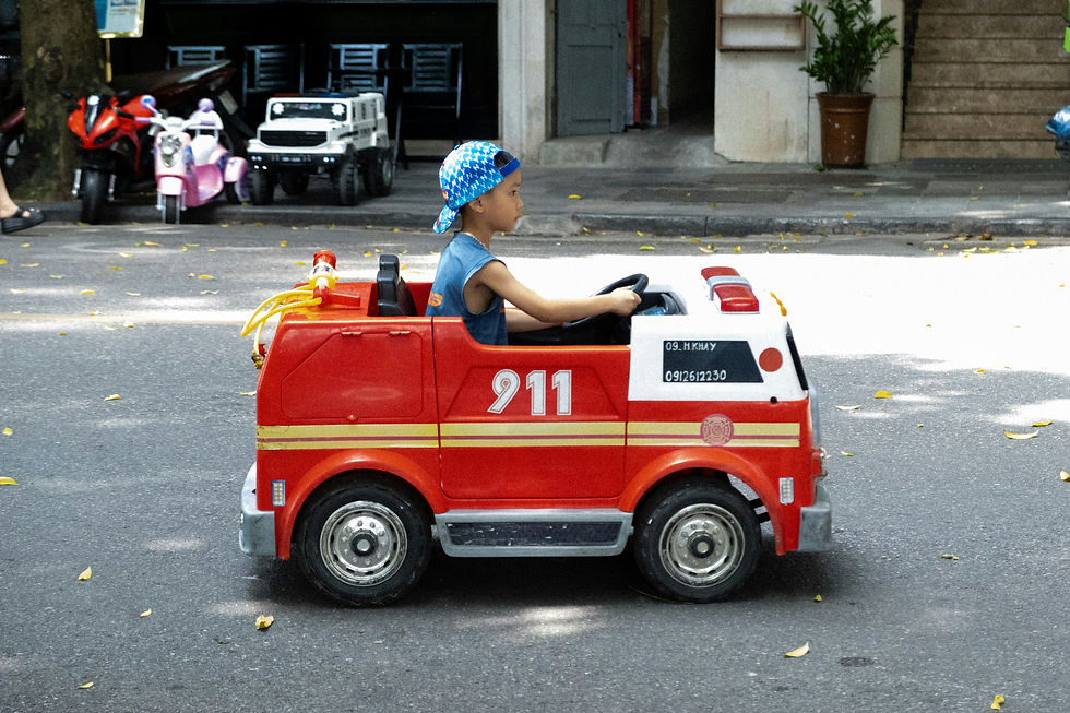 Child drives toy fire truck with 911 on side