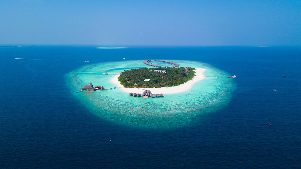 A serene aerial view of a private island, surrounded by vibrant turquoise waters and pristine white sandy beaches.