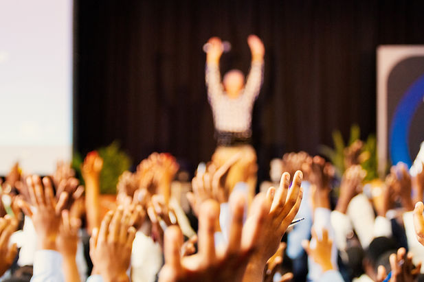 Raised hands at a conference. Image by Jaime Lopes