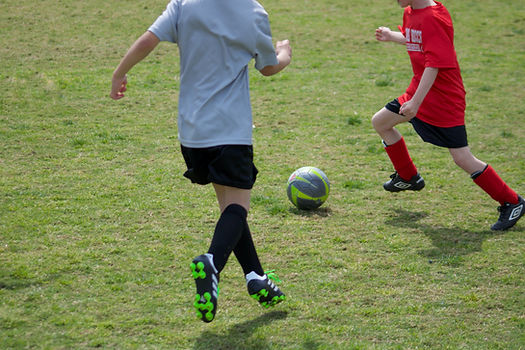 Close up of young footballers kicking football during training match
