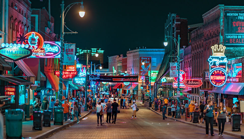 Beale Street in downtown Memphis, Tennessee, illuminated with iconic neon signs and live music venues at night.