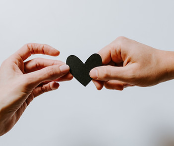 Two hands holding a paper heart | Image by Kelly Sikkema