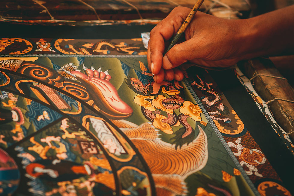 An artist meticulously adds intricate details to a vibrant traditional Nepali thangka painting.