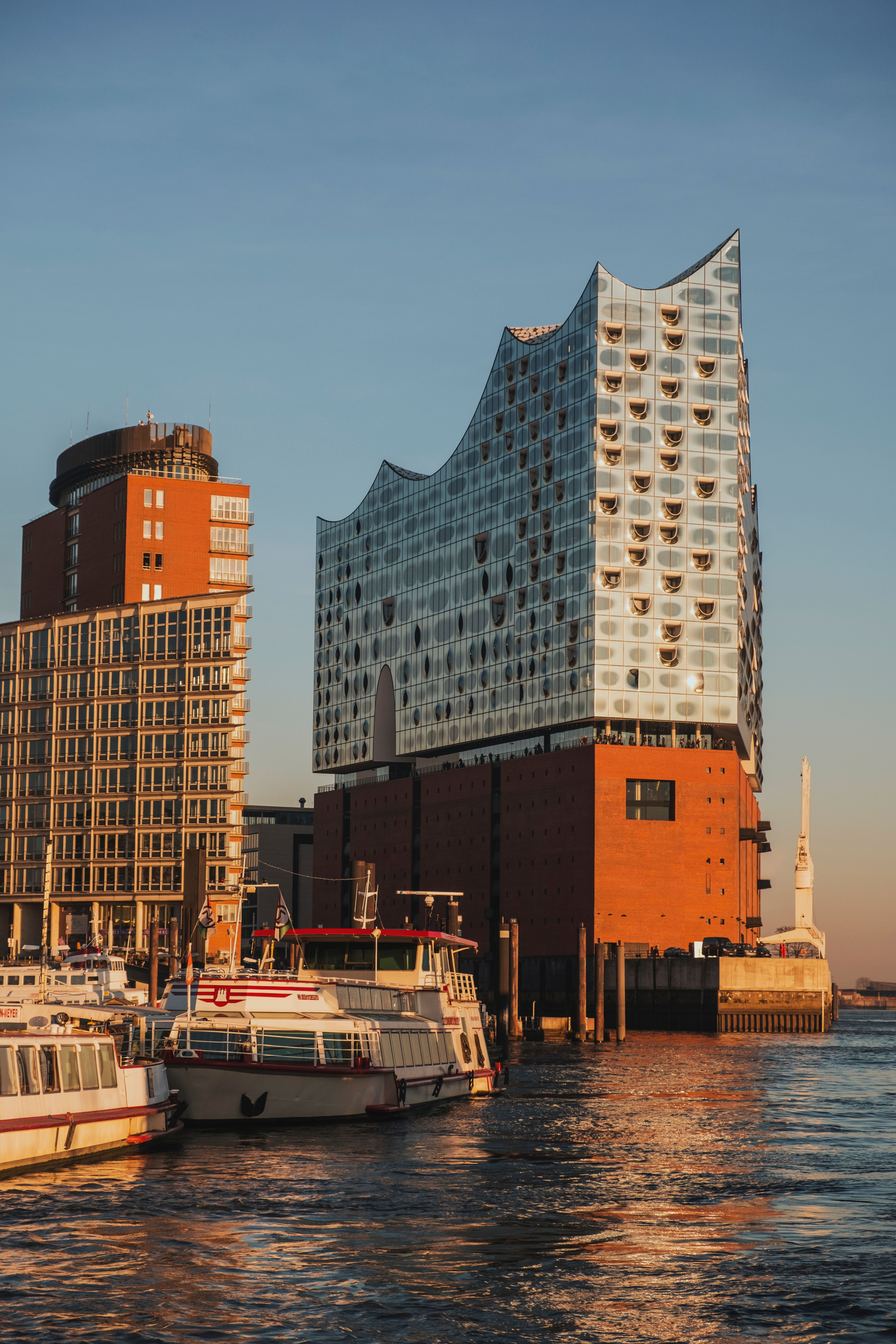 „Das Hamburger Rathaus und ein angrenzender Kanal, beleuchtet vom warmen Licht eines Sonnenuntergangs.“