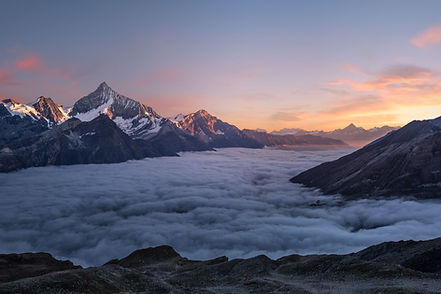 Mountain scene with mountain peaks, rock, snow and cloud in the valley