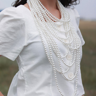 young girl with large layers of white strands of pearls