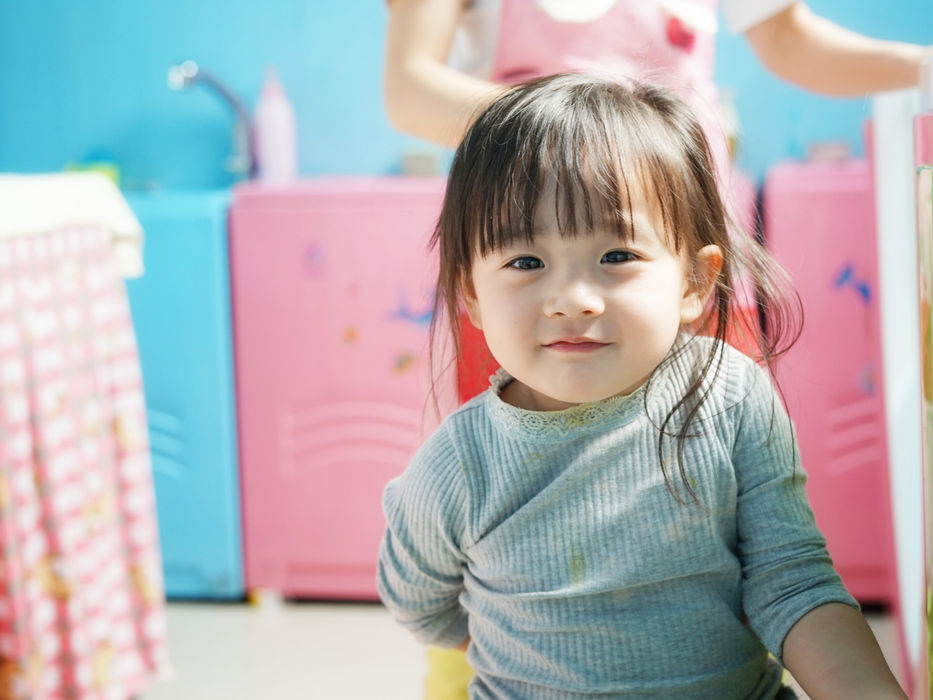 おもちゃのキッチンで遊ぶ笑顔の女の子