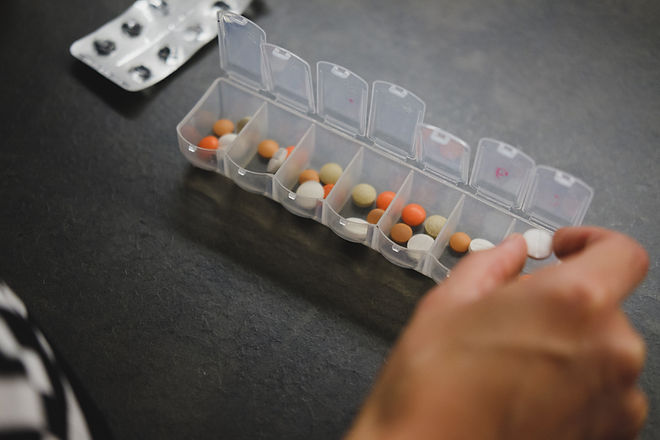 This is an alt text of a person taking vitamins and supplements