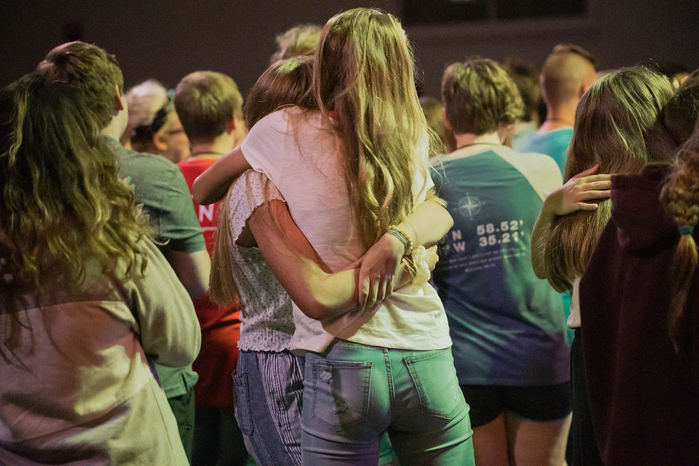 Photo of a group of people supporting each other at a large gathering..