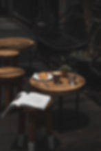 Table ronde de café avec magazine, plante, verre d’eau, café et croissant, ambiance esthétique et inspirante