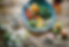 Image of a plate with a variety of healthy foods on and around a plate including avocados, eggs, kale, tomatoes, and more.