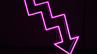 a neon sign of an arrow pointing down
