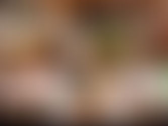 A variety of liquor bottles are displayed on backlit shelves, showcasing diverse labels and vibrant colours in a bar setting.