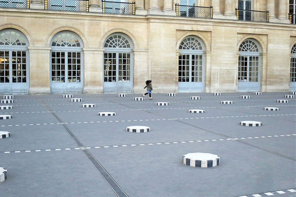Child runs across a courtyard with striped black and white circular columns. Large arched windows and beige walls form the background.
