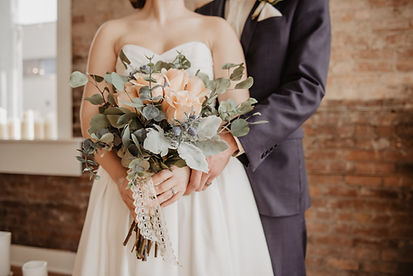 Bride and groom celebrating with arms raised at an oceanfront destination wedding by Elegant Elevation Events