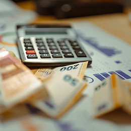 Ein Taschenrechner und Euro-Geldscheine stehen für Steuerprüfung - Symbolbild zum Steuerstrafrecht