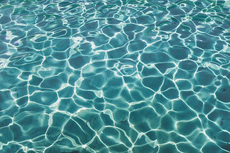 The surface of aquamarine water catching the light in abstract patterns.