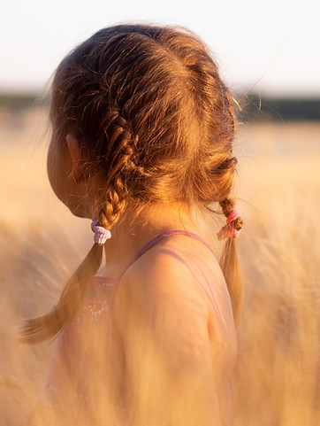 Child looking away in a field after children's therapy in Denver