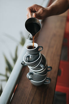 Pouring coffee into cups that are stacked