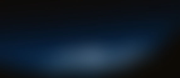 Snowy mountain peaks under a star-filled night sky, glowing blue in a serene, dark landscape.