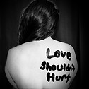 "Love Shouldn't Hurt" painted on woman's back