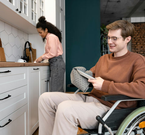 Man with in wheelchair smiling washing dishes