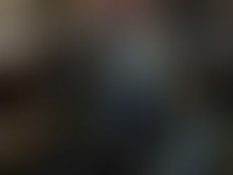 Bustling indoor market scene with people dining and shopping. Stained glass windows, colorful flags, and food stalls create a vibrant atmosphere.