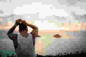 man putting hair in bun