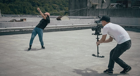 Photo d'un tournage en extérieur avec l'équipe Mele.vision, utilisant un stabilisateur et une caméra.