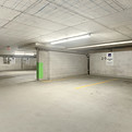 Leere Tiefgarage mit grünen Akzenten, Parkplatznummern und Deckenbeleuchtung, Haus & Gebäudeservice Kohl