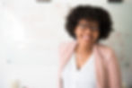 Black woman wearing glasses and a pink blazer looking at the camera