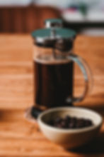 French press with cacao beans in a nearby bowl
