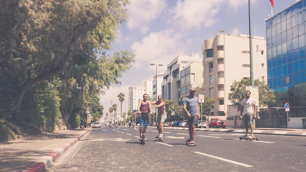Young adults skateboarding on an empty street