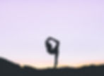 outline of a woman doing yoga asana dancer's pose at sunset