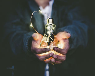 On this image a man holds a lightbulb, representing a great idea