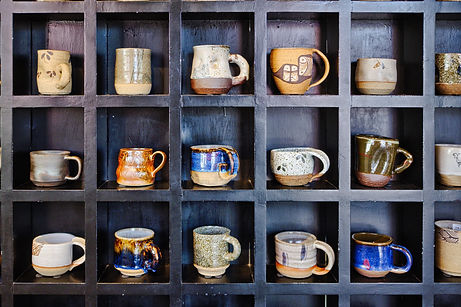 variety of coffee mugs on a shelf